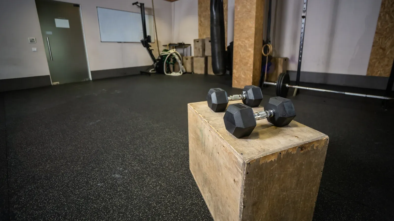 Inrett hemmagym i ett garage med power rack, skivstång och gummigolv