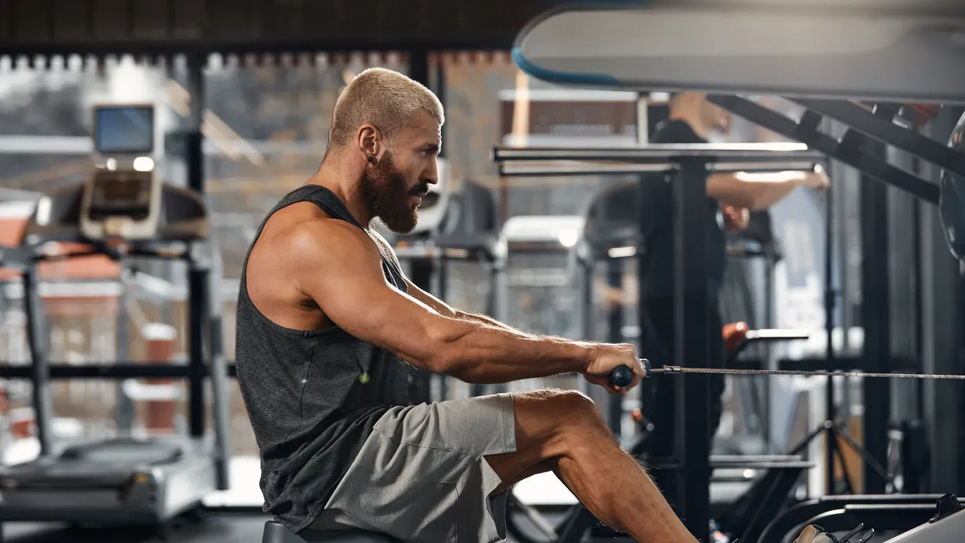 Person som kör intervaller på en roddmaskin i ett gym