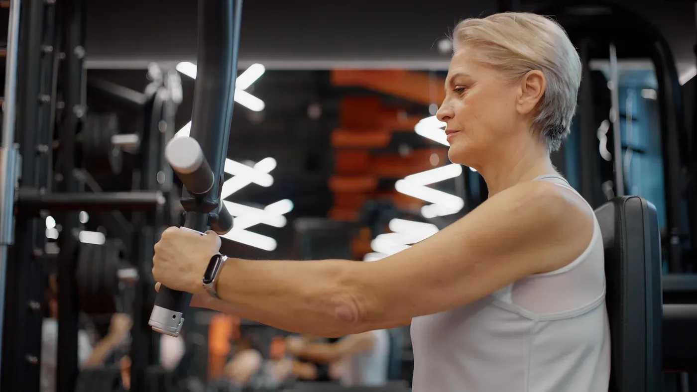 Kvinna tränar i en kabelmaskin på gym