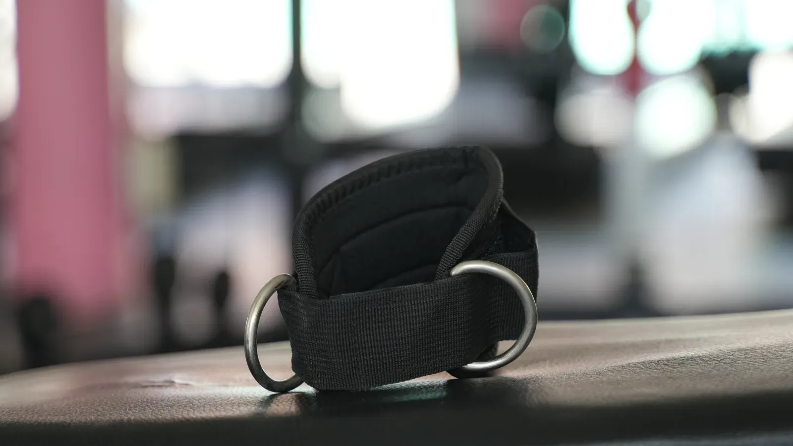 Lyftarbälte och lyftremmar på en bänk i ett gym